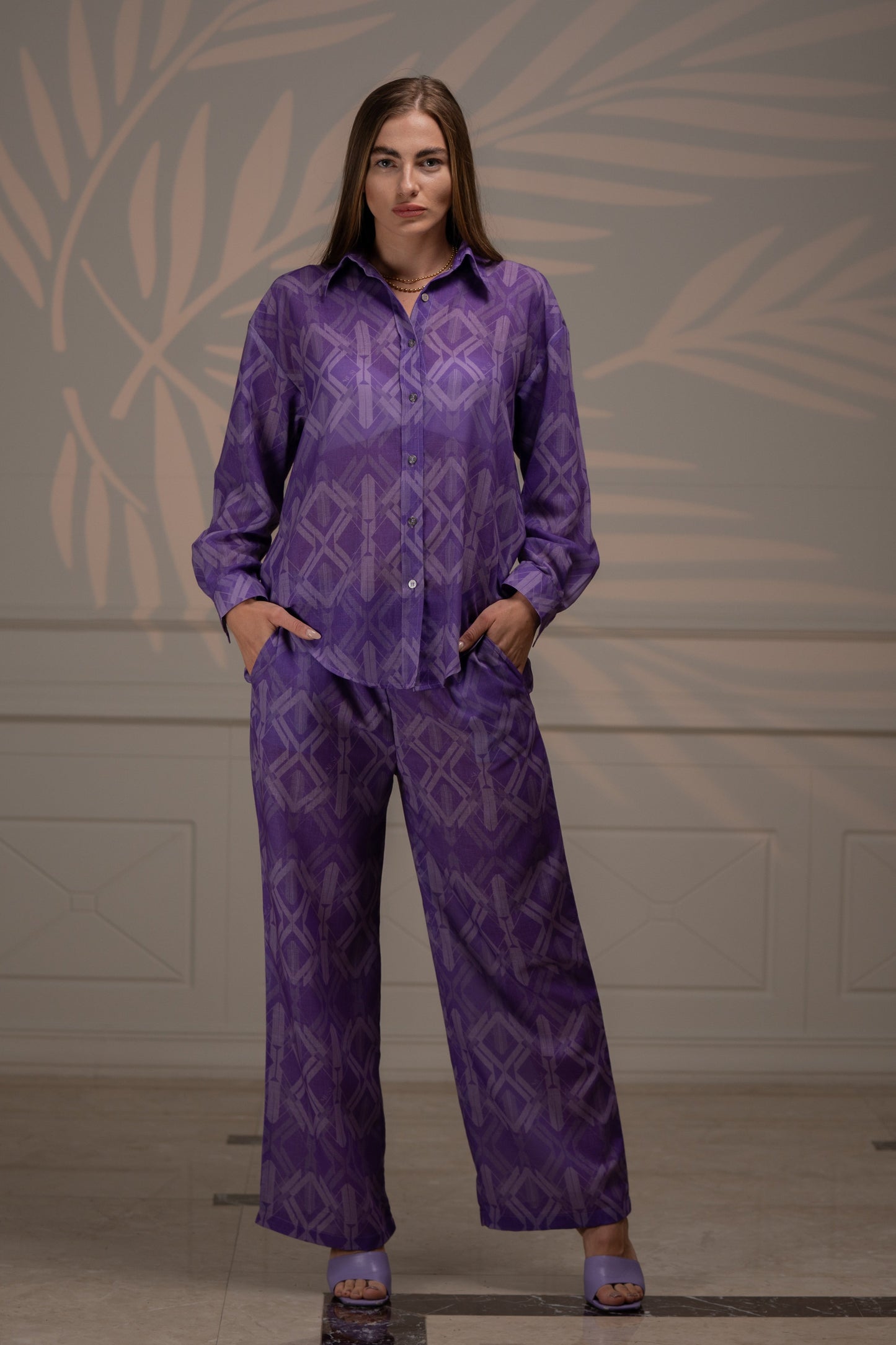 
A relaxed-fit linen Sunline Shirt in Purple with a classic button-front design, long sleeves, and a curved hem. The lightweight, breathable fabric has subtle texture, perfect for casual or beachwear. Styled untucked over white shorts for a laid-back summer look.
